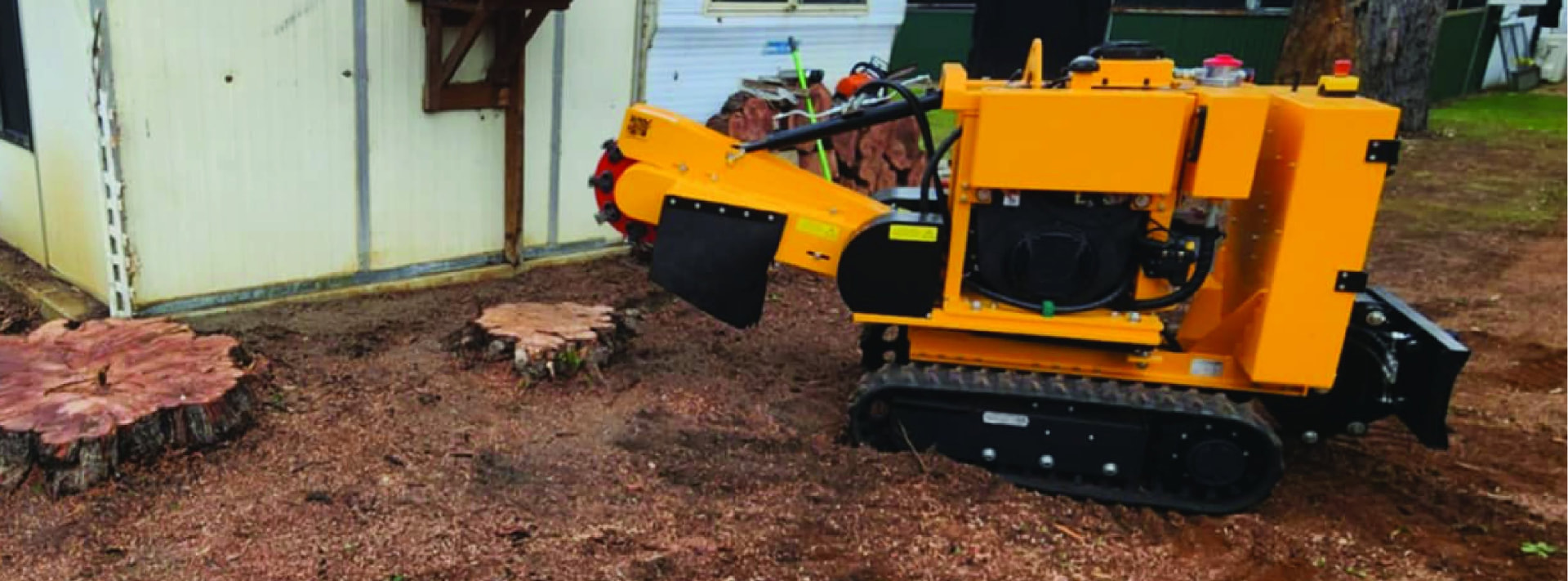 Savvy tracked stump grinder beside freshly ground stumps